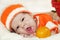 Cute yawning newborn baby dressed in a knitted orange costume wi