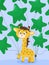Cute yellow giraffe with green balloons in its paw and tail is going to celebrate holiday