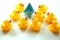 Cute yellow rubber ducks and one paper origami boat in blue color.