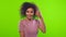 Cute young african american smiling woman turns and flirts on green screen