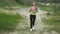 Cute young blond lady in sports uniform listening music in headphones and walks around