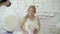 Cute young blonde woman in wedding dress with flowers bouquet posing for photographer in studio on background huge ice