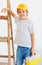 Cute young boy, foreman standing near the ladder