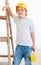 Cute young boy, foreman standing near the ladder