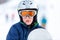 Cute young boy in gray helmet and orange googles, in blue jacket holds snowboard on white snow background. winter sport