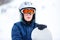 Cute young boy in gray helmet and orange googles, in blue jacket holds snowboard on white snow background. winter sport