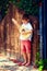 Cute young boy playing guitar near the summer old fence