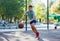 A cute young boy plays basketball on the street playground in summer. Teenager in a green t-shirt with orange basketball ball