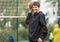 Cute young boy plays basketball on street playground. Teenager with orange basketball ball outside. Hobby, active lifestyle, sport