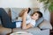 Cute young boy white t shirt sitting on the couch in the living room with laptop and study. Home education, self education