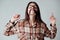 Cute young brunette girl in check shirt playing with hair