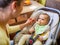 Cute young caring caucasian mother feeds her charming little six-month-old daughter