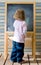 Cute young caucasian boy writing on a blackboard