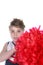 Cute young cheerleader holding large red pompom