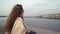 Cute young curly girl looks at the river