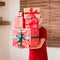 Cute young girl carrying stack of christmas presents, smiling. Happy kid at christmas.