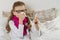 Cute young girl child in glasses sneezing in a tissue blowing