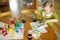 Cute young girl dyeing Easter eggs at home. Child painting colorful eggs for Easter hunt. Kid getting ready for Easter celebration