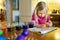 Cute young girl dyeing Easter eggs at home. Child painting colorful eggs for Easter hunt. Kid getting ready for Easter celebration