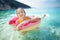 Cute young girl floating on toy ring at Myrtos beach, the most famous and beautiful beach of Kefalonia, a large coast with