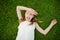 Cute young girl having fun on a grass on the backyard on sunny summer evening