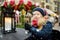 Cute young girl having rooster-shaped lollipop on traditional Christmas fair in Riga, Latvia. Child enjoying sweets, candies and
