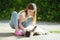 Cute young girl with her cat on sunny autumn day. Adorable child petting her kitty