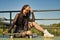 Cute young girl with heterochromia and punk style with one hand resting on a skateboard and the other hand resting on her head