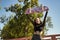 Cute young girl with punk style raising a skateboard above her head and sticking out her tongue