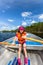 Cute young girl rowing a rowboat on a lake with blue summer sky in the background.