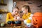 Cute young girl sitting at a table, decorating little white pumpkins with her mother, a cancer patient. DIY Halloween.