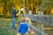 Cute young girl stroking an alpaca at a farm zoo on autumn day. Child feeding a llama on an animal farm. Kid at a petting zoo at