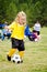 Cute young girl in uniform playing soccer