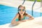 Cute young girl wearing swimming goggles having fun in outdoor pool. Child learning to swim. Kid having fun with water toys