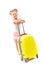 Cute young girl in white shirt, pink shorts and sunglasses stand near yellow suitcase