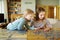 Cute young girls playing puzzles at home. Children connecting jigsaw puzzle pieces in a living room table. Kids assembling a