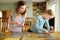 Cute young girls playing puzzles at home. Children connecting jigsaw puzzle pieces in a living room table. Kids assembling a