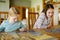 Cute young girls playing puzzles at home. Children connecting jigsaw puzzle pieces in a living room table. Kids assembling a