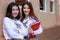 Cute and young girls wearing Japanese, Korean style schoolgirl uniform, holding books and pose to camera together with fun and