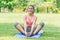 Cute young healthy sport teen sitting smiling on yoga mat outdoor park garden