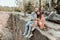 Cute young loving couple relaxing while sitting on the rock near lake