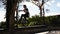 Cute young man bmx rider rides in street on pathway and jumps on wall curb.