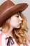 Cute young pensive woman in cowboy hat with golden hair