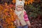 Cute young russian baby girl stylish dressed in warm white fur handmade jacket blue jeans boots and hooked hat teddy bear posing i