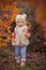 Cute young russian baby girl stylish dressed in warm white fur handmade jacket blue jeans boots and hooked hat teddy bear posing i