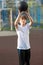Cute young sporty boy in white t shirt plays basketball on his free time, holidays, summer day on the sports ground. Sport