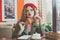 Cute young woman drinking coffee and eating french croissant in cafe