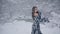 Cute young woman in fairy tale image in grey royal dress stands in snow