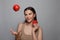 Cute young woman with fresh red tomatoes. Female brunette juggling the tomato