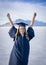 Cute Young woman in her graduation cap and gown showing excitement after graduating